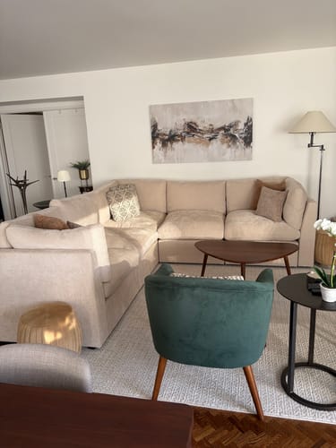 Reviewer's 'Abstract Neutral Splash' canvas shown hanging on a wall above a beige sectional sofa in a living room.