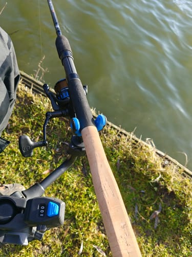 Recensent toont de CLICKER COUNTER bevestigd aan een visopstelling bij het water, die '001' aangeeft.