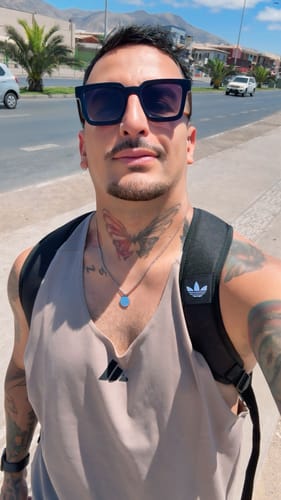 Cliente luciendo su colgante Totem Classic en una selfie al aire libre.