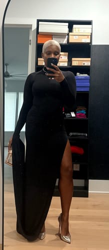 Customer takes a mirror selfie in the black Naked Draped Sleeve Maxi Dress, showing the high side slit and draped sleeve.