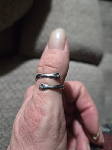 Customer wearing the silver Hug From Heaven Ring, shaped like arms hugging their thumb.