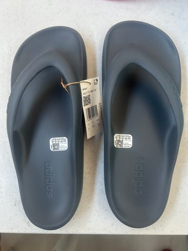Customer's new pair of adidas Adilette Lumia Slides in Onix gray with the product tag still attached.
