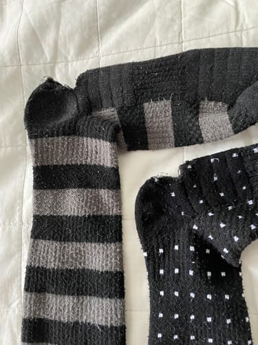 Kundens randiga Diasocks stödstrumpa som visar ett hål vid hälen.