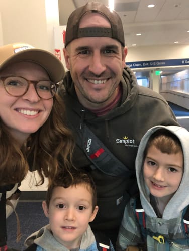 Customer wearing the dark Patagonia trucker hat backward, showing the mesh back in a family photo.