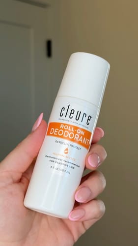 Customer holding the white bottle of Cleure Roll-On Deodorant in their hand.