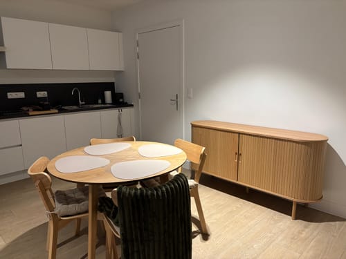 De ronde eiken Crow eettafel van een recensent, opgesteld in een eetkamer met stoelen.