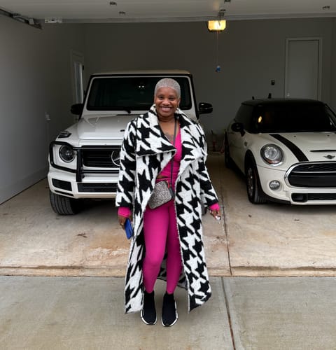 Reviewer wearing the oversized Bouclé Houndstooth Coat open over a bright pink outfit in a garage.