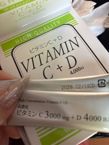レビュー投稿者が「ビタミンC+D」の個包装を手に持っているところ。背景には商品の箱が見える。