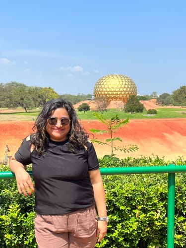 Reviewer wearing the Captain gold and black round sunglasses outdoors on a sunny day.