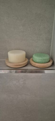 Customer's two stylish bamboo drainer dishes with shampoo and conditioner bars in a walk-in shower.