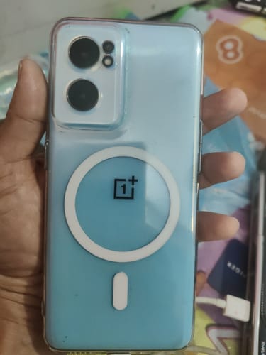 Customer holding a light blue One Plus Nord CE 2 phone in the clear Anti-Yellow Magsafe case, showing the white magnetic ring.