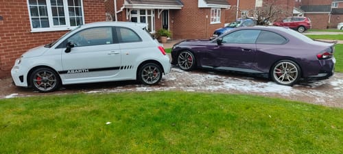 Customer's two sparkling clean cars, one white and one purple, on a driveway after using the Apex Warrior Kit.