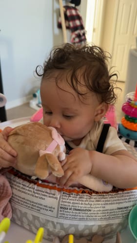 A customer's baby kisses the plush Personalized Day & Night Layla talking doll.