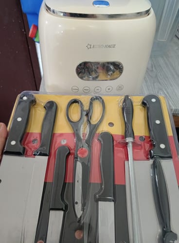 Customer holds the packaged 8-piece knife set with the cream-colored Eurohauz Healthy Rice Cooker in the background.