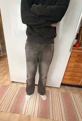 Kunde in der gut sitzenden Star Denim Jeans, die nach dem Waschen verwaschen und grau aussieht.