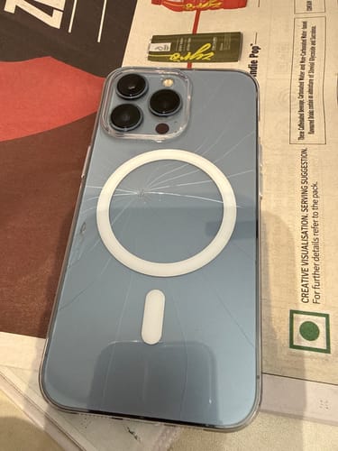 Customer's transparent MagSafe case on an iPhone, with large cracks radiating from the white center ring.
