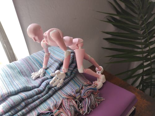 Customer's pink Rose Quartz Stickybones figure in a dynamic crawling pose on a colorful blanket.