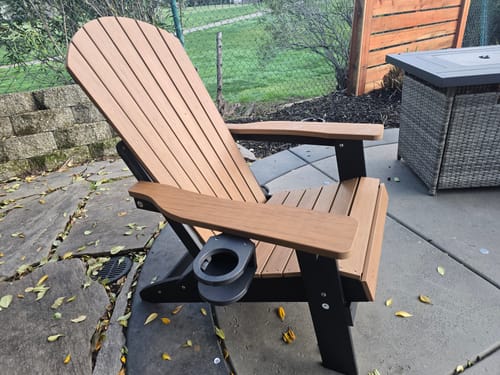 Customer's two-tone Folding Adirondack Chair with a cup holder, assembled on an outdoor patio.
