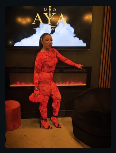 Reviewer posing in a lounge wearing the vibrant Bare Body Print Closed Toe Leggings.