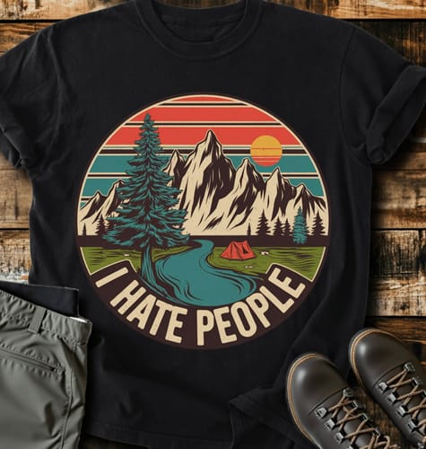 Customer's black 'I Hate People' T-shirt with a colorful mountain graphic, styled flat with hiking gear.