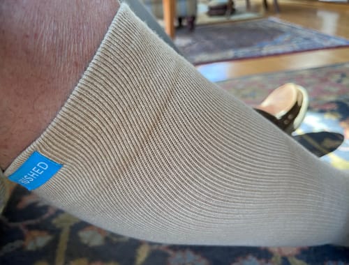 Close-up of a customer wearing the beige, ribbed Performance Eucalyptus Compression Sock on their leg.