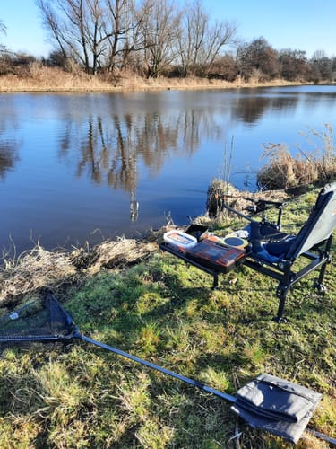 Recensent toont zijn zelfdragende bijzettafel, gemonteerd aan een visstoel aan het water.