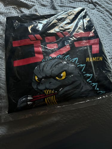 Customer's RAMEN MONSTER TEE in its clear packaging, showing the graphic of a monster eating ramen.
