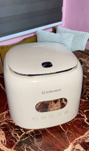 Reviewer's sleek, cream-colored Eurohauz Healthy Rice Cooker sitting on a marble-patterned surface.