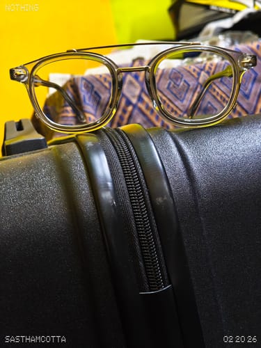 Customer's close-up of the Milano Transparent Grey Wayfarer Sunglasses resting on a black suitcase.