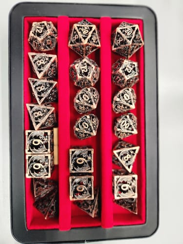 Customer's hollowed metal dragon dice sets neatly arranged in a black case with a red felt interior.