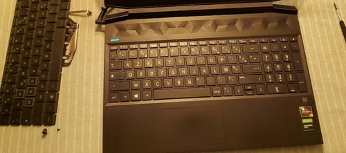 Client montrant le clavier Azerty français installé dans son PC, avec l'ancien clavier démonté à côté.