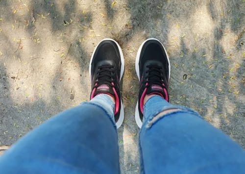 Reviewer's overhead view of their black and pink Easy Fit shoes with thick white soles.