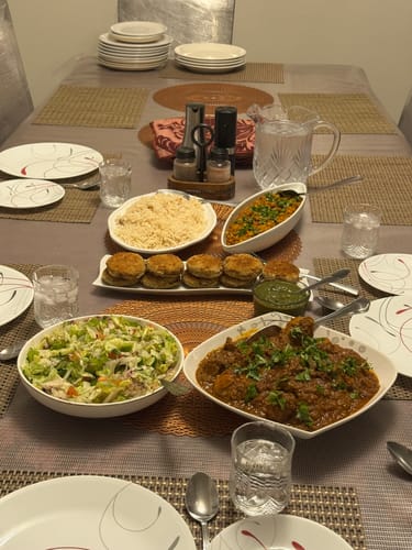 Customer's meal featuring the Halal Whole Chicken cooked into a hearty curry, served on a set dinner table.