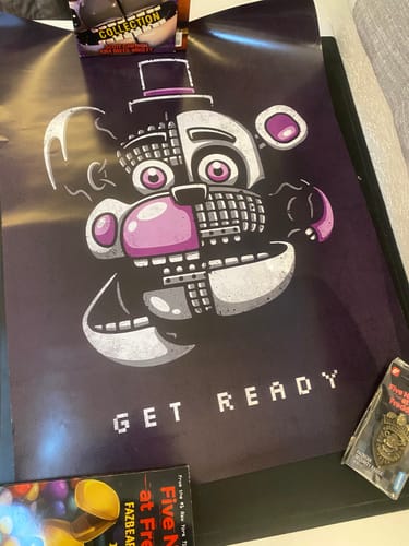 Customer's Five Nights at Freddy's poster laid out with other collectibles, showing the detailed animatronic print.