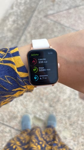 Customer's Maxfit Smartwatch with a rose gold case and white strap, shown on a wrist with the activity tracker screen active.