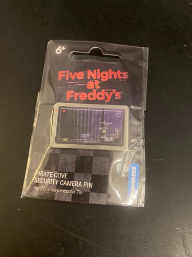 Customer's Five Nights At Freddy's lenticular pin in its original sealed packaging, resting on a dark surface.