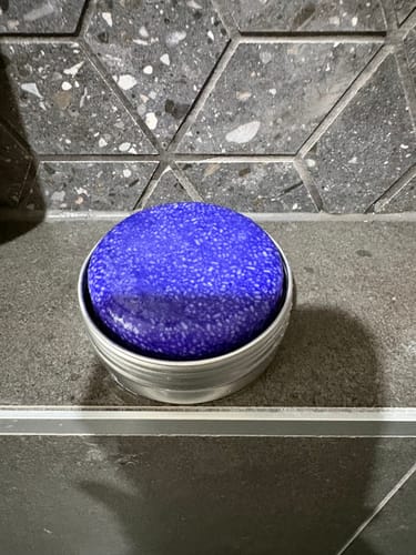 Customer's purple shampoo bar sitting in a travel tin, demonstrating the Travel Tin Drainage Tray.