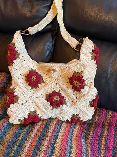 Customer's completed Garden Rose Hobo bag, handmade in cream-colored yarn with red 3D roses.