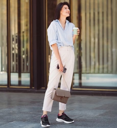 Customer standing outdoors wearing black Easy Fit shoes with pink details and white soles.