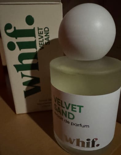 Close-up of a customer's Velvet Sand perfume bottle with its large, round cap next to the box.