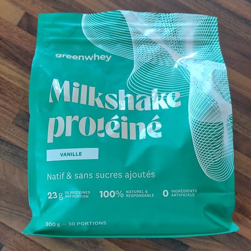 Avis client : le sachet vert de Milkshake protéiné saveur vanille sur une table en bois.