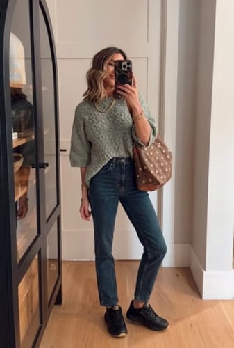 Customer wearing black Soft Stride shoes with dark wash jeans and a knit sweater indoors.