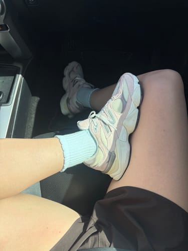 Reviewer sitting in a car, wearing the baby blue Dual-Direction Grip Basics socks with chunky sneakers.