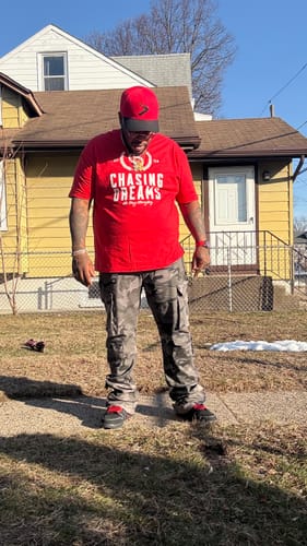 Customer standing outdoors wearing the camo Vortex Cargo Stacked Denim, showing the pants' fit and design.