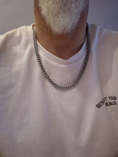 Cliente usando la Cadena Cuban Link plateada de 8mm sobre una camiseta blanca.