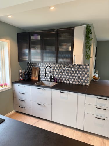 En kundes kjøkken med Latte hexagon veggfliser som en stilig bakvegg mellom hvite og mørke skap.