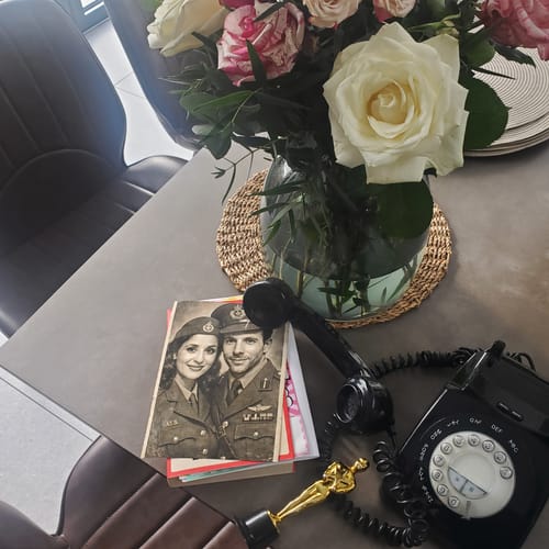 Customer's table with 1940s props for the Murder Mystery Game Kit, including a vintage phone and Oscar-style trophy.