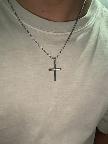 Primer plano de un cliente que lleva el Crucifix Pendant con su cadena de cuerda.