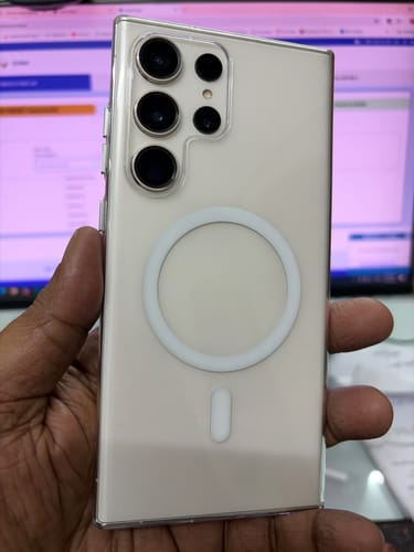 Customer holding a Galaxy S23 Ultra with the clear Anti Yellow Magsafe case, showing the back and white magnetic ring.