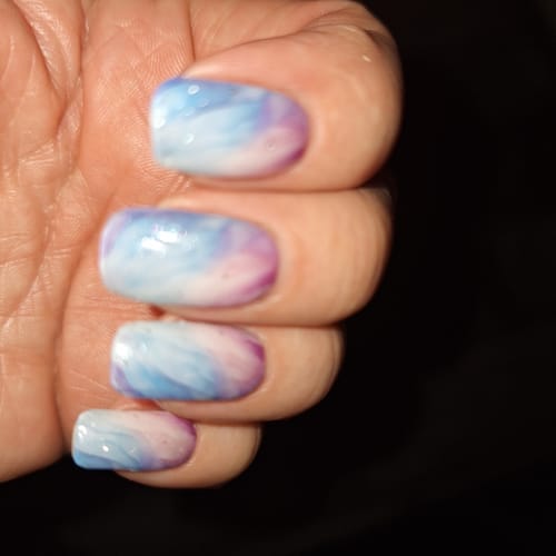 Nahaufnahme der Hand einer Kundin, die die UV-Gel-Nagelfolien 'Glitter Rose Ombré' trägt.